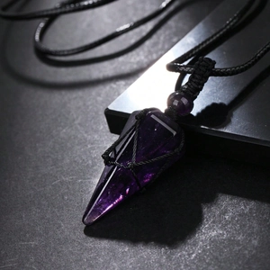 Macro shot of purple amethyst pendulum pendant with intricate black woven mesh and rope chain
