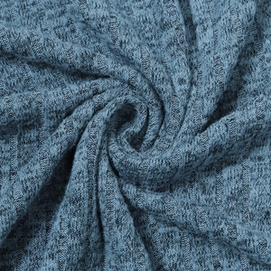Macro view of blue-grey ribbed knit fabric showing soft texture and vertical patterns