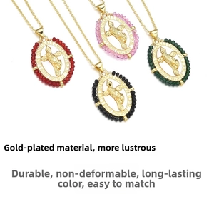 Dettaglio di collane con croce placcate in oro con perle rosse rosa nere e verdi