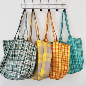 Vue détaillée de quatre sacs cabas en toile à carreaux colorés avec design à grande capacité