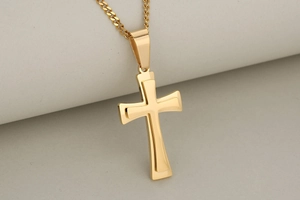 Close-up of double-layered golden stainless steel cross pendant on matching chain