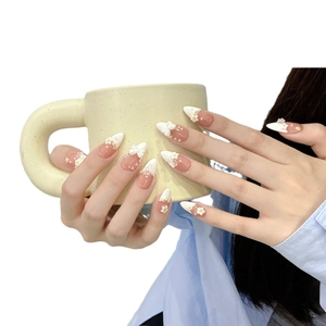 Nude pink almond press-on nails with white French tips, 3D floral and bow accents