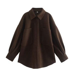 Détail d'une veste en laine marron foncé avec grandes poches et coutures de précision