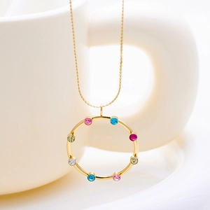 Detalle de collar de acero dorado con piedras preciosas redondas de colores en un colgante circular
