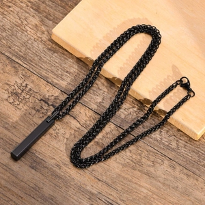 Macro shot of a sleek black tungsten rectangular bar pendant on a woven wax cord necklace