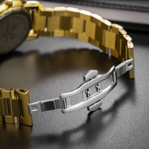 Detailed macro view of the gold and silver metal butterfly clasp on a classic watch band