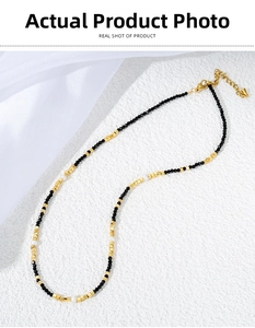 Close-up of black spinel beads, white pearls and gold metal accents on a beaded necklace