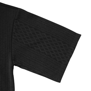 Close-up of black knit sleeve featuring premium diamond texture and fine ribbed cuffs