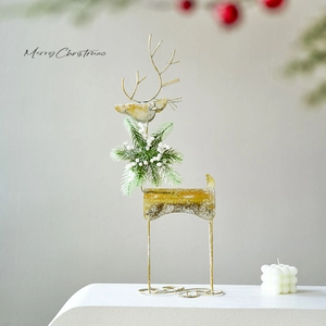 Festive gold metal reindeer decoration with greenery on a white minimalist table
