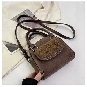 Detail of dark brown corduroy bag with plush faux shearling trim and PU leather handle