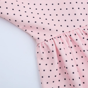Detailed view of the pink and black polka dot fabric with high-density pleated craftsmanship
