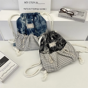 Detailansicht der Tie-Dye-Kordelzugrucksäcke mit Karomuster und Baumwollträgern