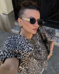 Close-up of elegant puff sleeve blouse with leopard print and golden jewelry details