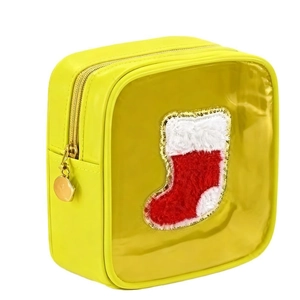 Macro detail of yellow makeup bag with transparent window and plush Christmas sock patch