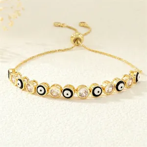 Detail of adjustable golden Evil Eye bracelet with enamel beads and clear cubic zirconia
