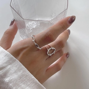 Detailed view of sterling silver geometric rings on hand with minimalist aesthetic