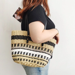 Handmade woven straw tote bag with rainbow striped contrast colors and black leather straps