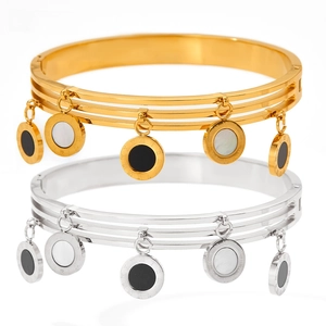 Close-up of three-tier stainless steel bangles with Roman numeral charms in gold and silver