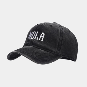 Close-up of NOLA letter embroidery on washed black cotton baseball cap in detail view