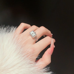 Detailed view of silver watch-style ring with shimmering zircons and mother-of-pearl dial
