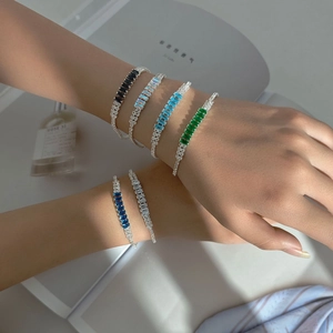 Macro shot of layered bracelets featuring colorful rectangular-cut cubic zirconia stones