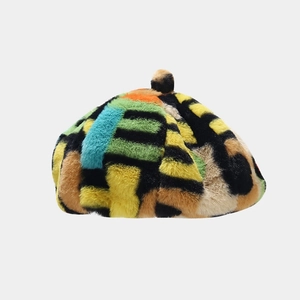 Détail d'un béret coloré en fausse fourrure douce avec motif abstrait et pompon