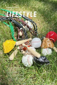Miniature baseball keychain set with wooden bat and leather glove on green grass