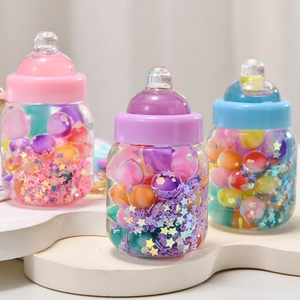 Close-up of three milk bottle keychains with colorful liquid glitter and pastel caps