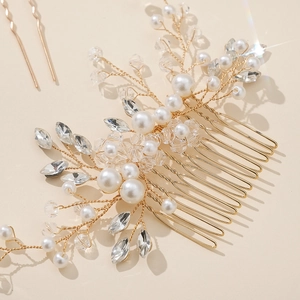 Set accessori capelli sposa in filo dorato con perle e strass su sfondo beige neutro
