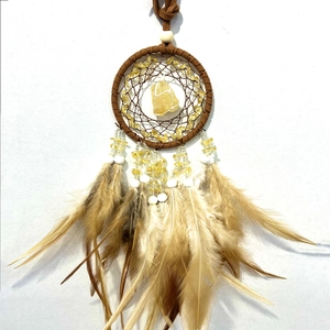 Detail of dream catcher with large yellow crystal, brown suede wrap and soft feathers