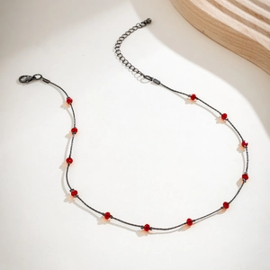 Detail of gothic dark grey chain necklace featuring eleven faceted red crystal beads