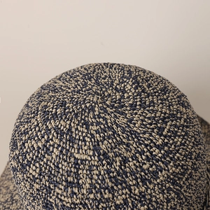 Détail de la couronne du chapeau en paille tressée bicolore avec motif en spirale serré