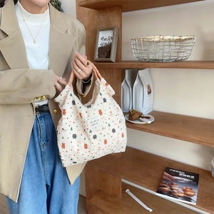 Close-up of white canvas tote with cartoon holiday patterns and textured fabric finish