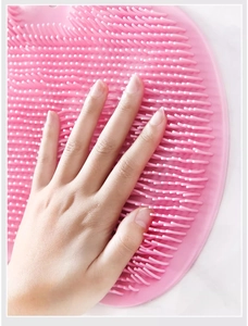 Close-up of pink silicone bath brush with soft bristles showing texture and flexibility