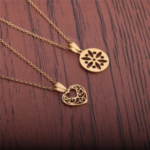 Golden stainless steel heart and hollow floral pendant necklaces on dark wood
