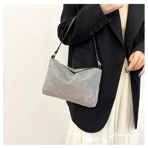 Close-up of a silver rhinestone shoulder bag worn by a model with a black blazer