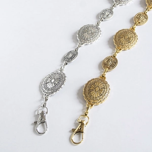 Detail of vintage embossed metal belt chains with lobster clasps in gold and silver