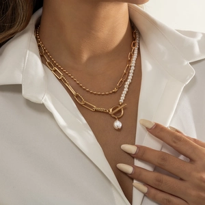 Elegant gold-tone layered necklace with faux pearls, OT buckle and teardrop tassel pendant