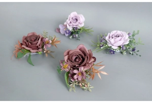 Detail of dusty rose and lilac silk corsages with decorative berries and lush faux greenery