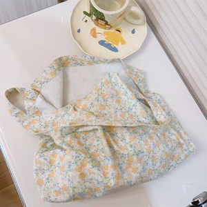 Detailed top view of a cream floral cotton tote bag with a soft yellow flower print