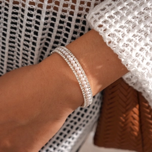 Close-up of layered bracelets with shimmering rhinestones and elegant white faux pearls