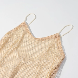 Detail of sheer beige mesh fabric with shimmering silver sequins and fine thin straps