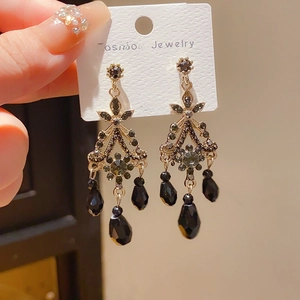 Close-up of vintage dark style tassel earrings with 925 silver needles and crystals