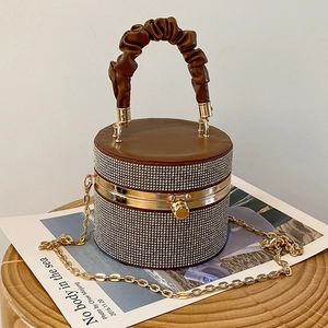 Brown rhinestone cylinder bucket bag with gold chain strap and pleated handle detail