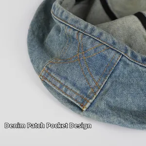 Detailed view of denim beret featuring orange contrast stitching on the pocket patch