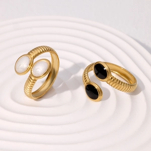 Detailed view of gold plated spiral rings with white shell and black onyx stones