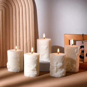Dettagli di rilievi di api e nidi d'ape su candele a pilastro avorio per decorazioni