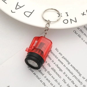 Close-up of a red mini LED flashlight keychain on a stylish decorative background