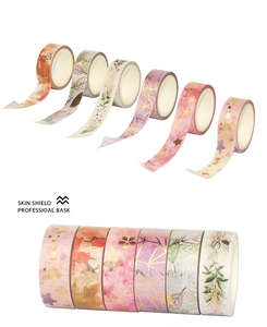 Close-up of 6 rolls of gold foiled washi tape with floral and geometric patterns