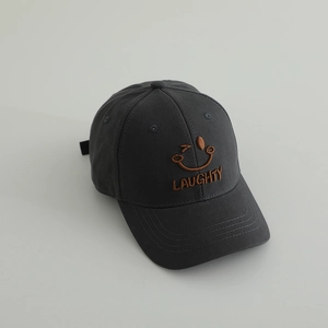 Close-up of charcoal grey baseball cap with brown embroidered wink face and LAUGHTY text